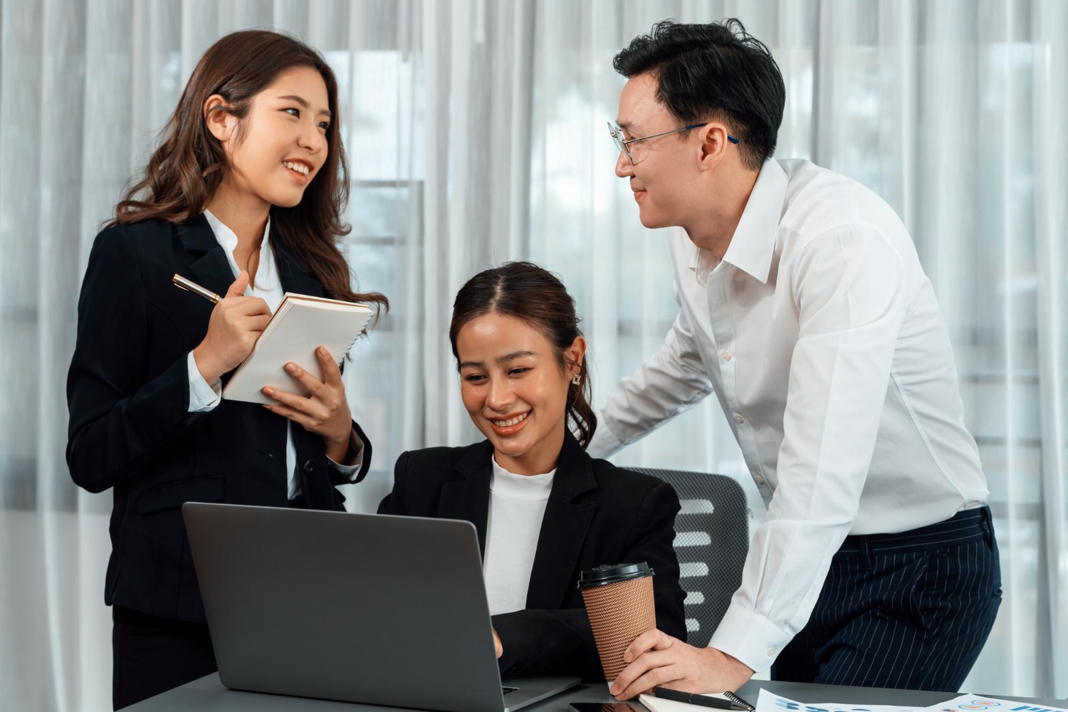 2 co-workers checking in regularly with the new employee to see how she is adjusting to the new working environment