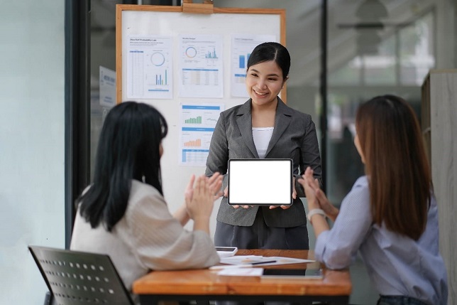 Female office worker presenting her company's mass recruitment service to partners