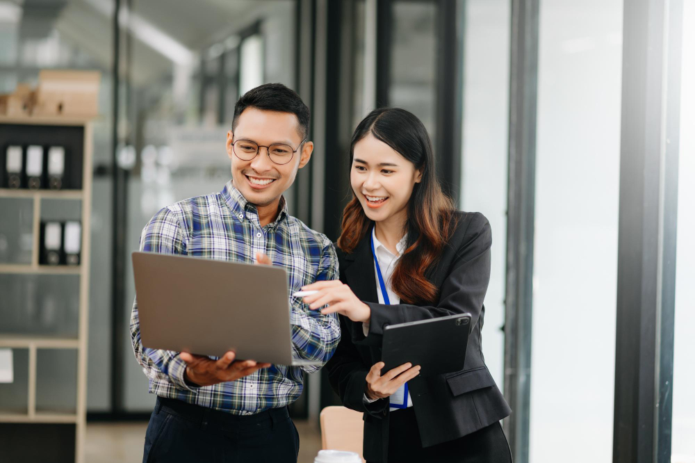 Hai chuyên gia đang thảo luận về lĩnh vực tư vấn nhân sự tại Hà Nội trên máy tính xách tay