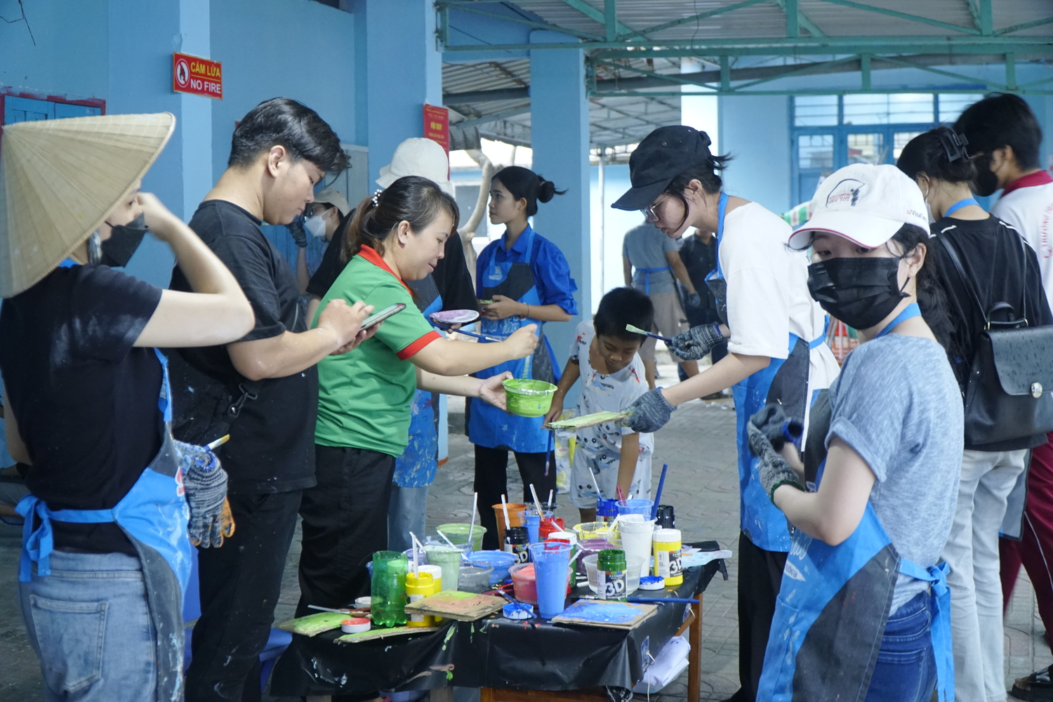 ManpowerGroup Vietnam’s employees and Sac Mau’s volunteers prepare paints and brushes to decorate the walls of Phuoc Loc Kindergarten in a CSR project