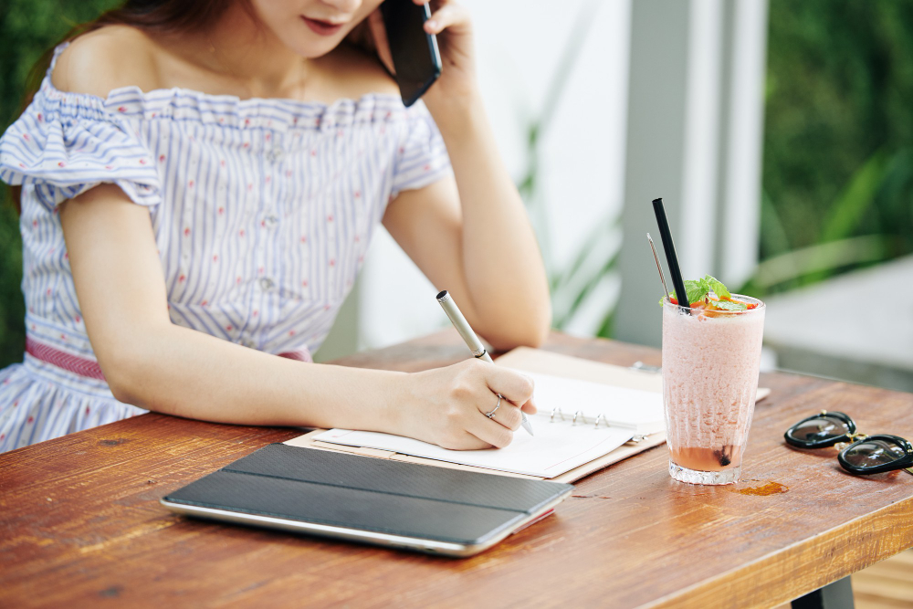 Female office worker taking notes of her achievements at work