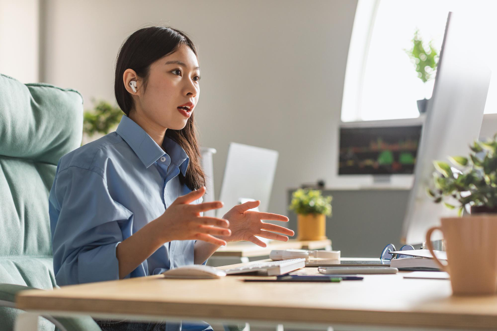 Female office worker practicing speaking aloud in front of the computer