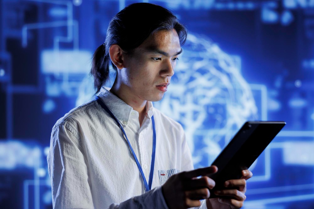 A tech worker using a tablet with a digital background