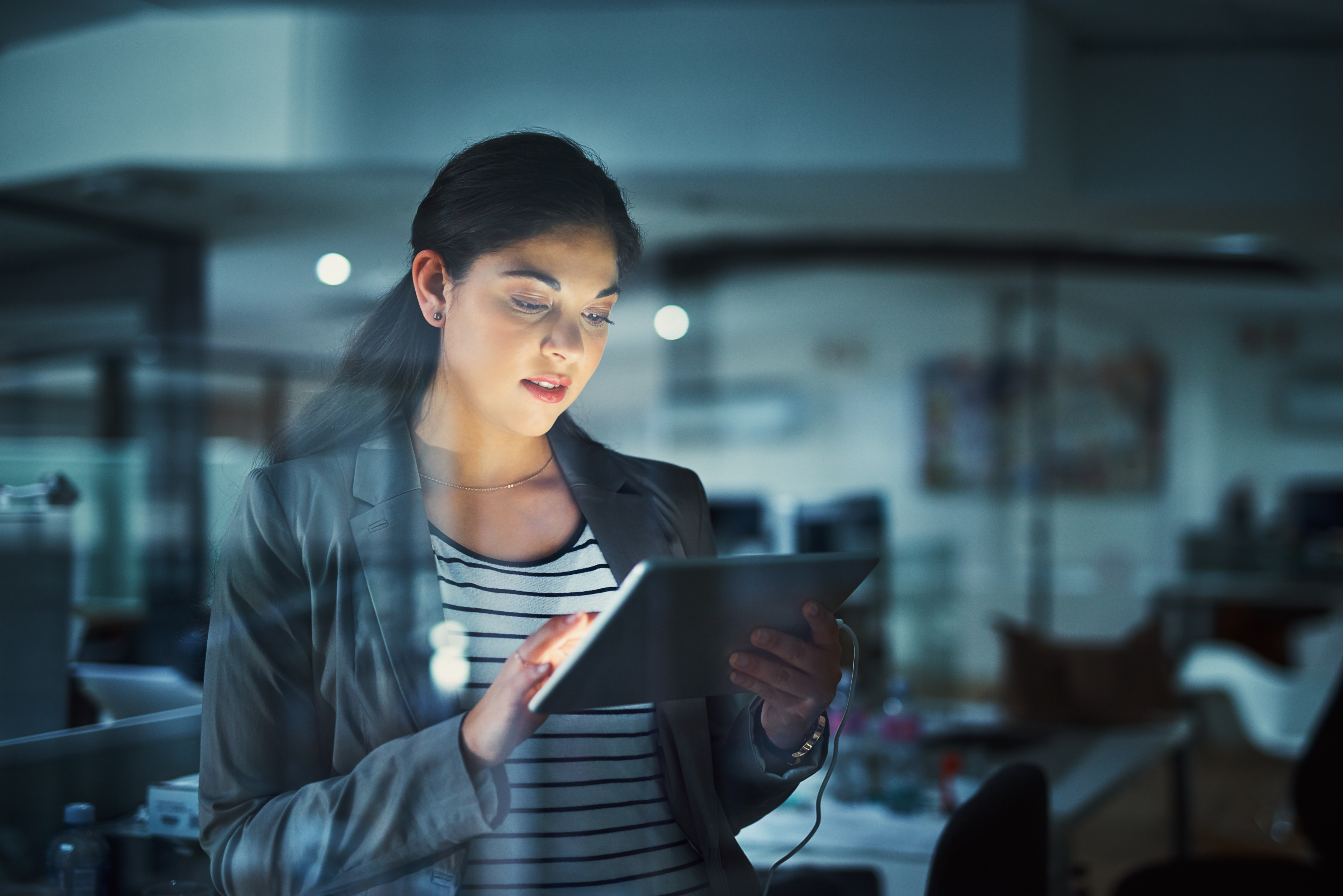 Female employee using a tablet to look up work in the office.