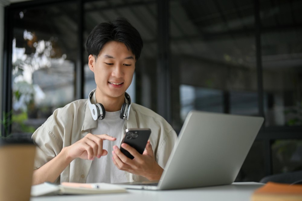 Male worker using devices to upgrade his social media presence.