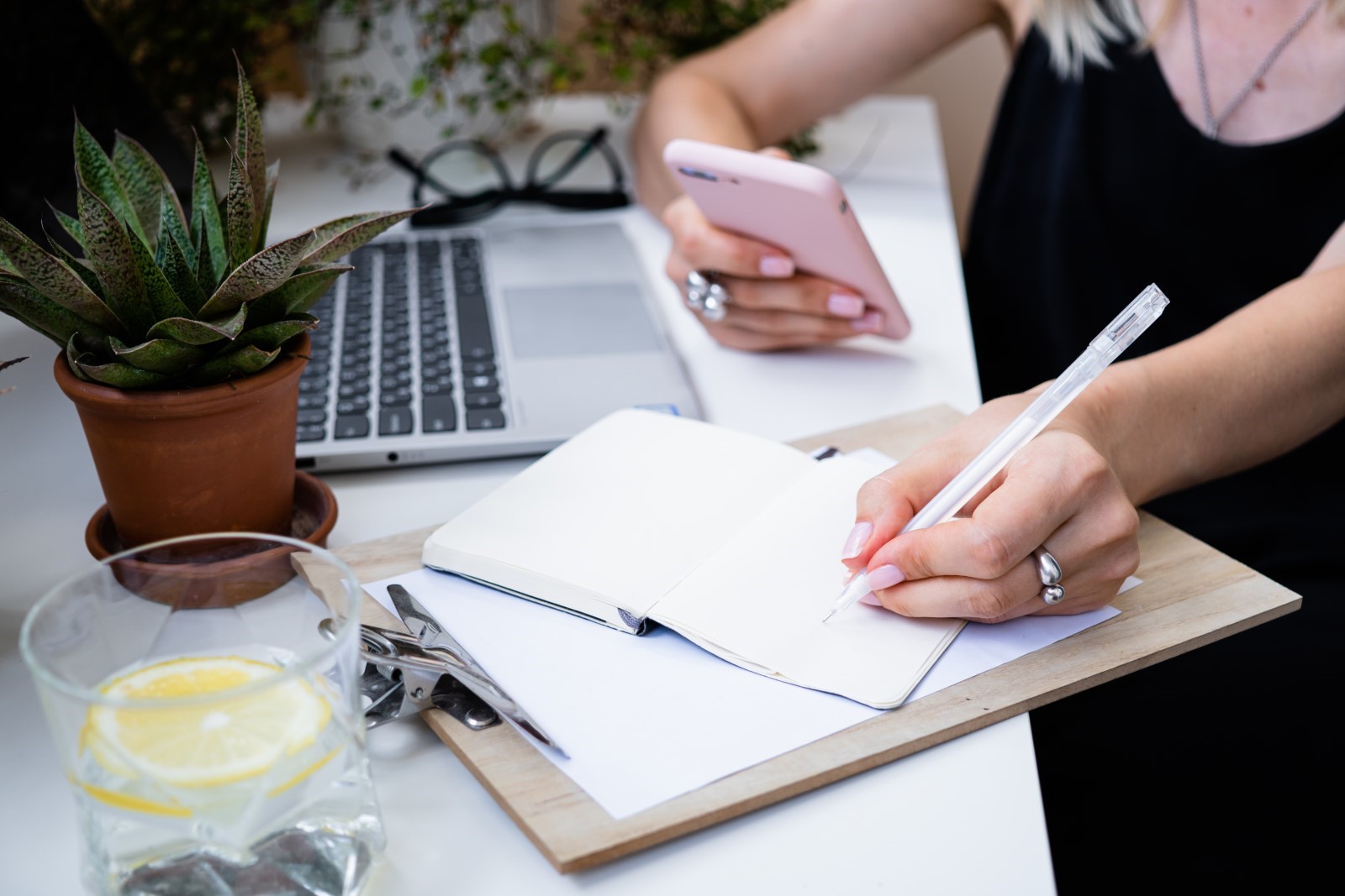 Office worker writing down a to-do list on a notebook  