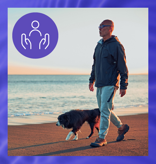 Man walking on beach with his dog, showing well-being as a major aspect of work-life balance