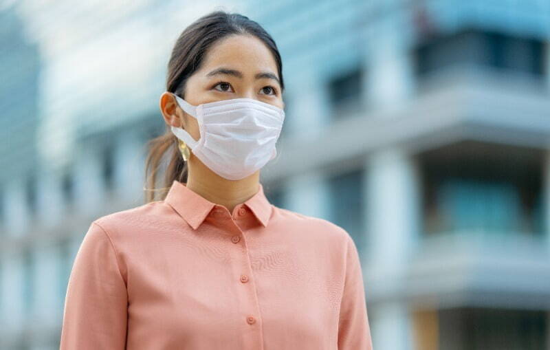 a female asian worker in bright orange shirt heading to a recruitment agency during COVID-19