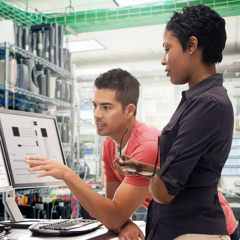 Manager and team member reviewing staffing outsourcing project documents in a manufacturing factory