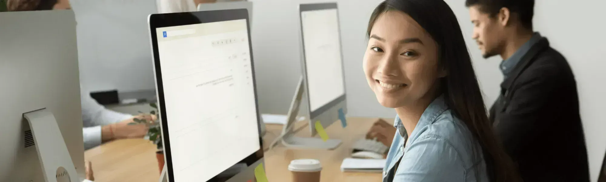 mixed office workers at recruitment headhunting executive search services agency looking at laptops and smiles